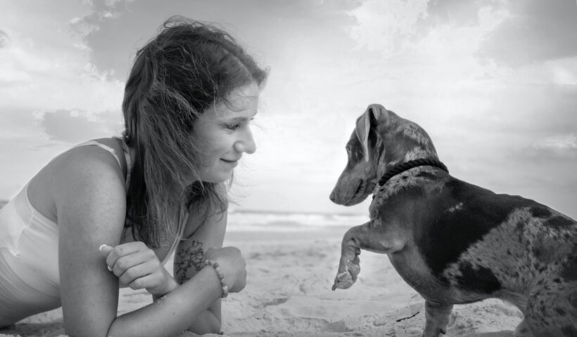 grayscale photo of woman holding dog