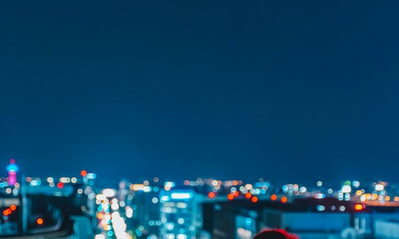 woman in white shirt standing on the city during night time