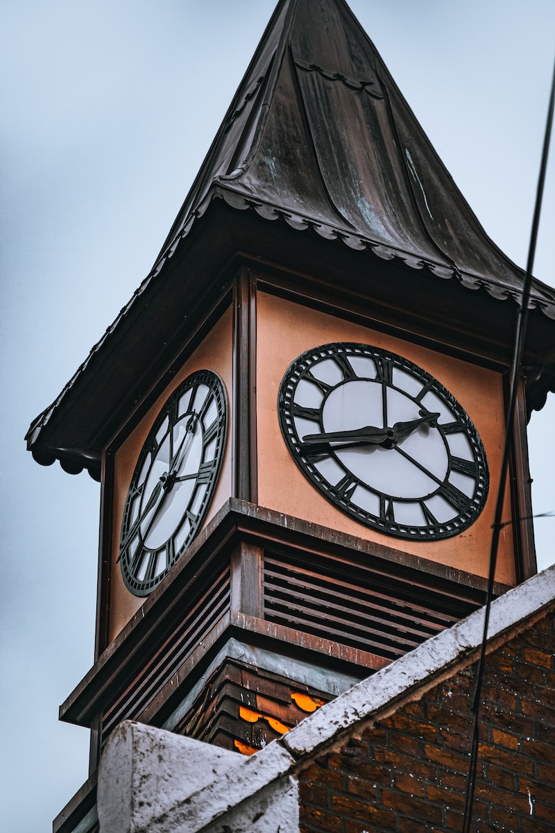 a clock tower with a weather vane on top of it