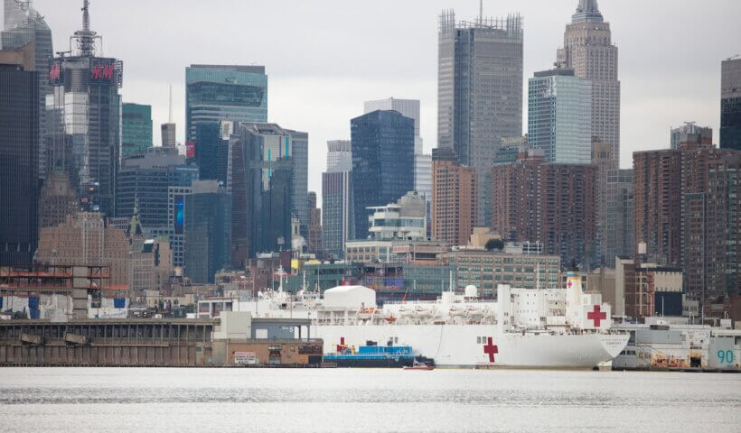 white ship on body of water near city buildings during daytime