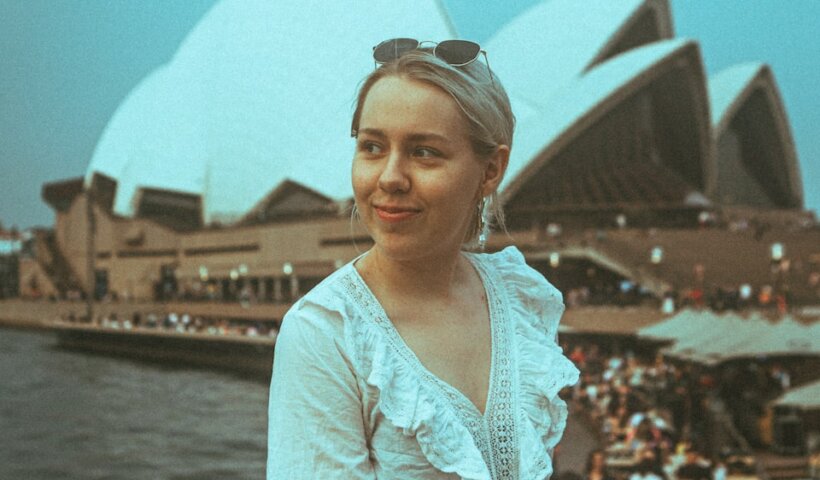 woman in white floral long sleeve shirt standing near body of water during daytime